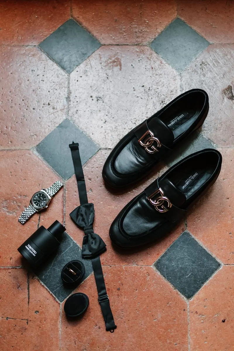 Schoenen, horloge, strik en parfum van de bruidegom op de tegelvloer