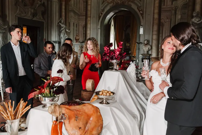 Gasten en bruidspaar rond de tafel met Italiaanse ham