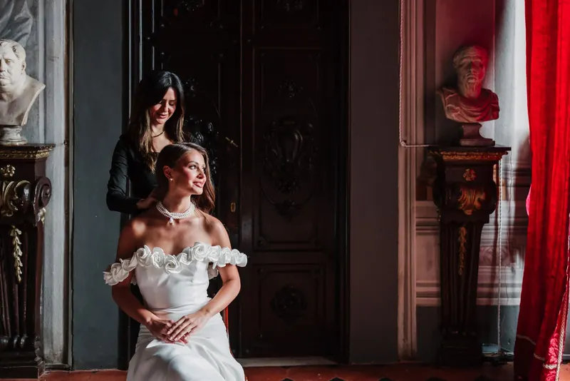 De laatste hand aan het kapsel van de bruid in het salon