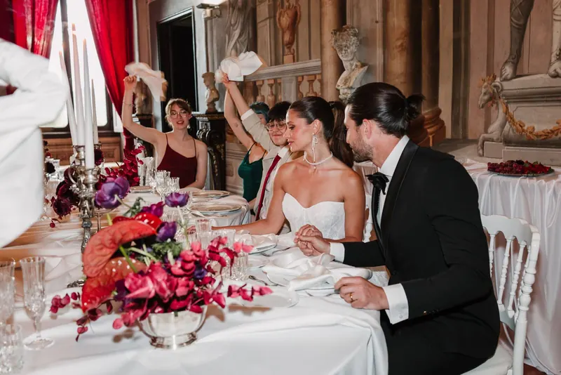 Het bruidspaar hand in hand aan de dinertafel