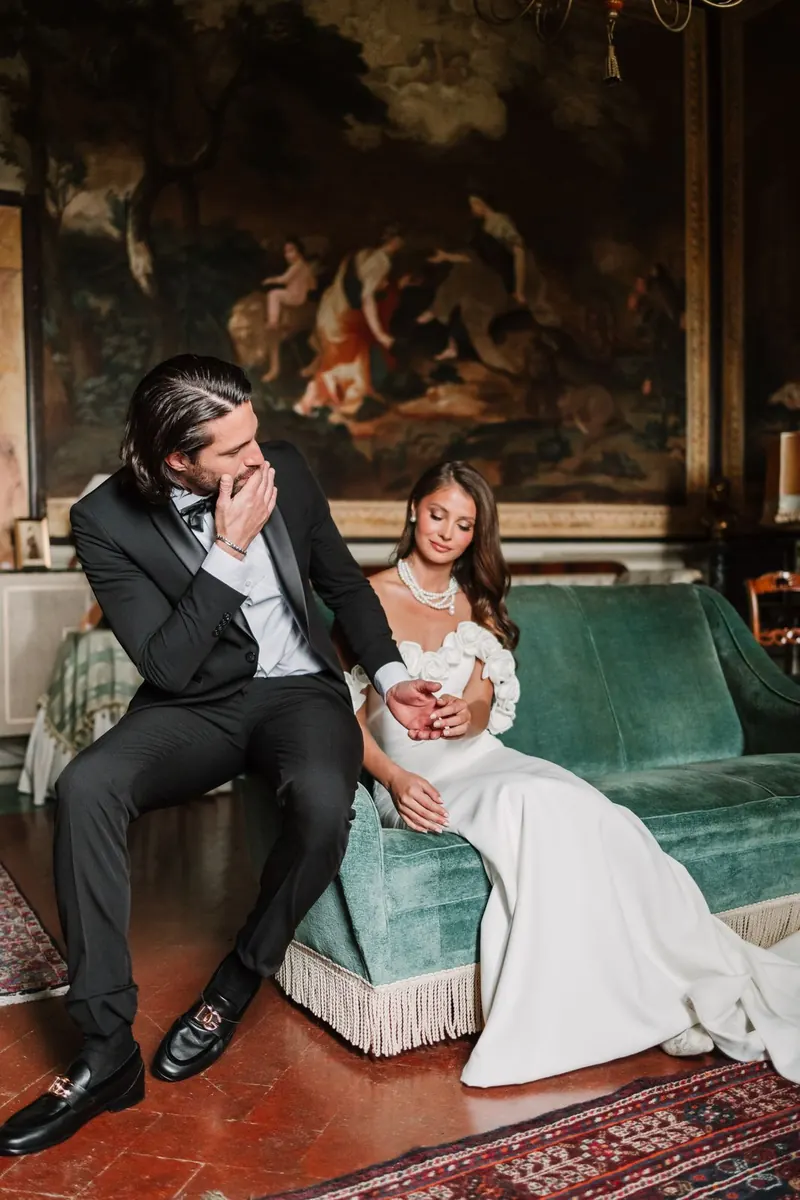 Het bruidspaar lacht samen in het salon van de villa
