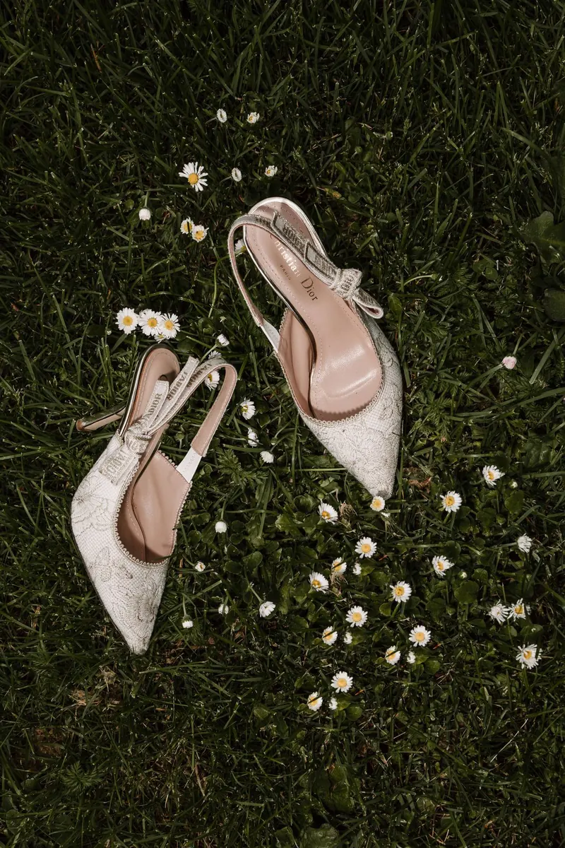 Bruidsschoenen in het gras tussen madeliefjes