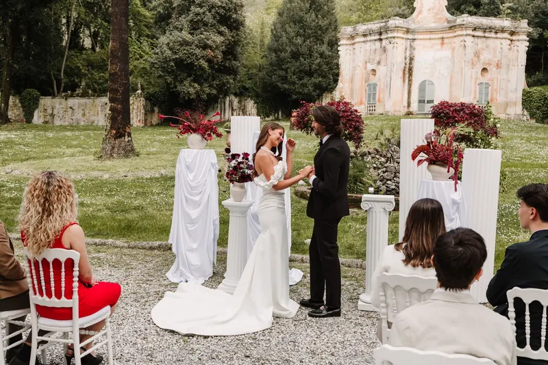 De gasten kijken toe tijdens de ceremonie in de tuin