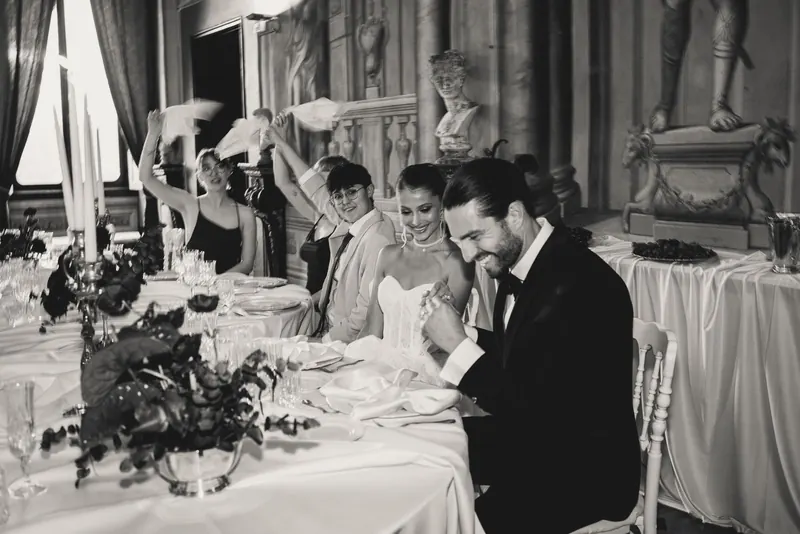 Het bruidspaar aan tafel tijdens het diner, monochrome foto