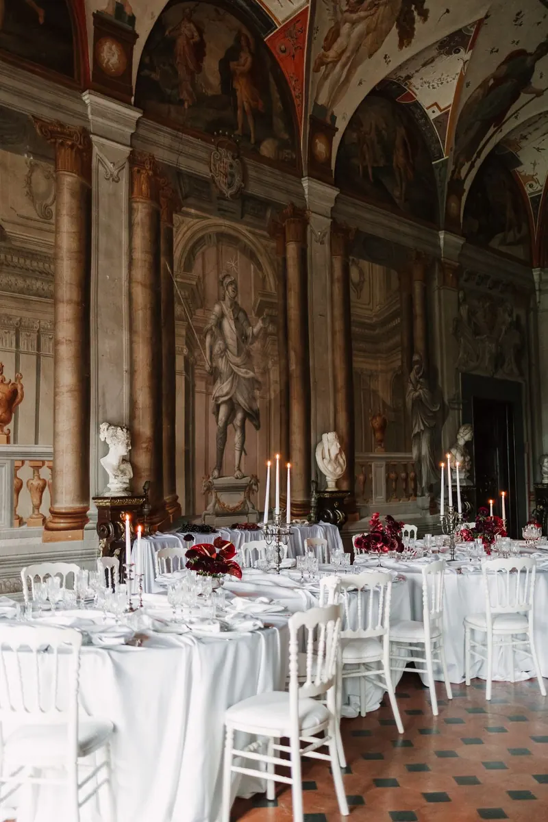 De gedekte dinertafels in de zaal met fresco's