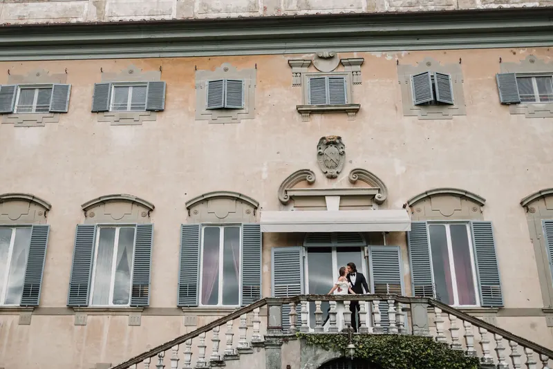 Het bruidspaar op het balkon van de gevel van Villa di Corliano