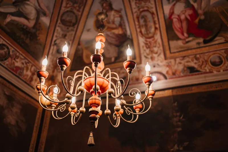 Kroonluchter onder een plafond met fresco's in de villa