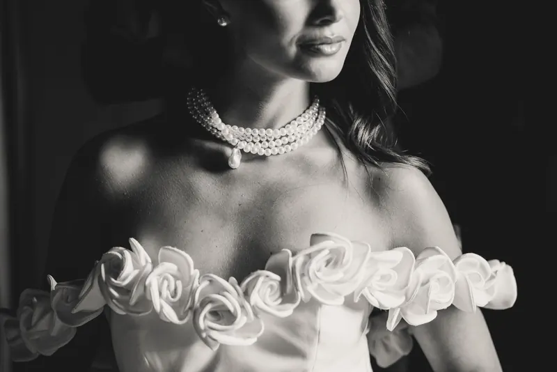 Parelketting en rozen van de jurk, monochrome detailfoto