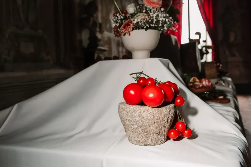Rode tomaten in een stenen schaal op de witte tafel