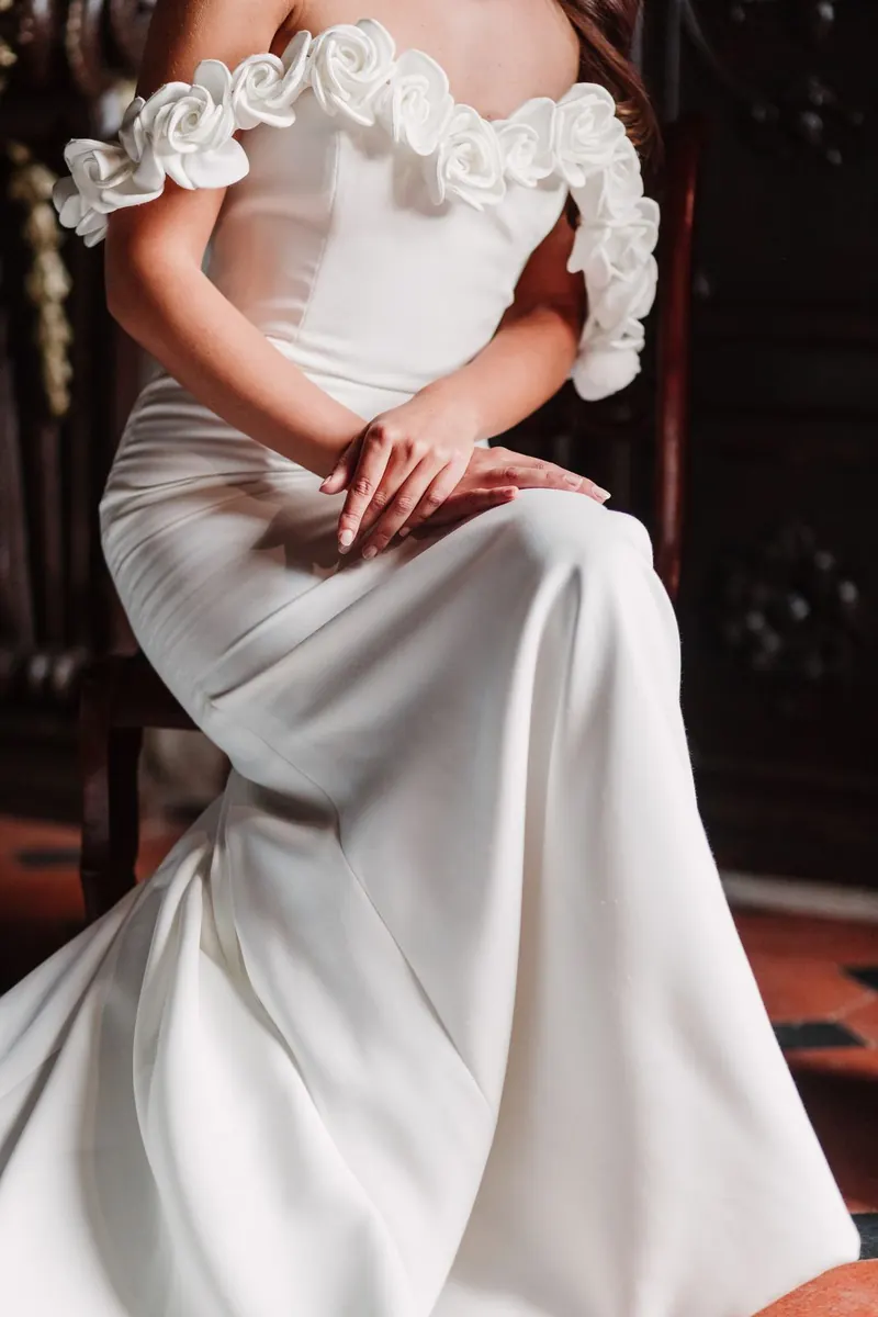 Detail van de trouwjurk met zijden rozen op de schouders