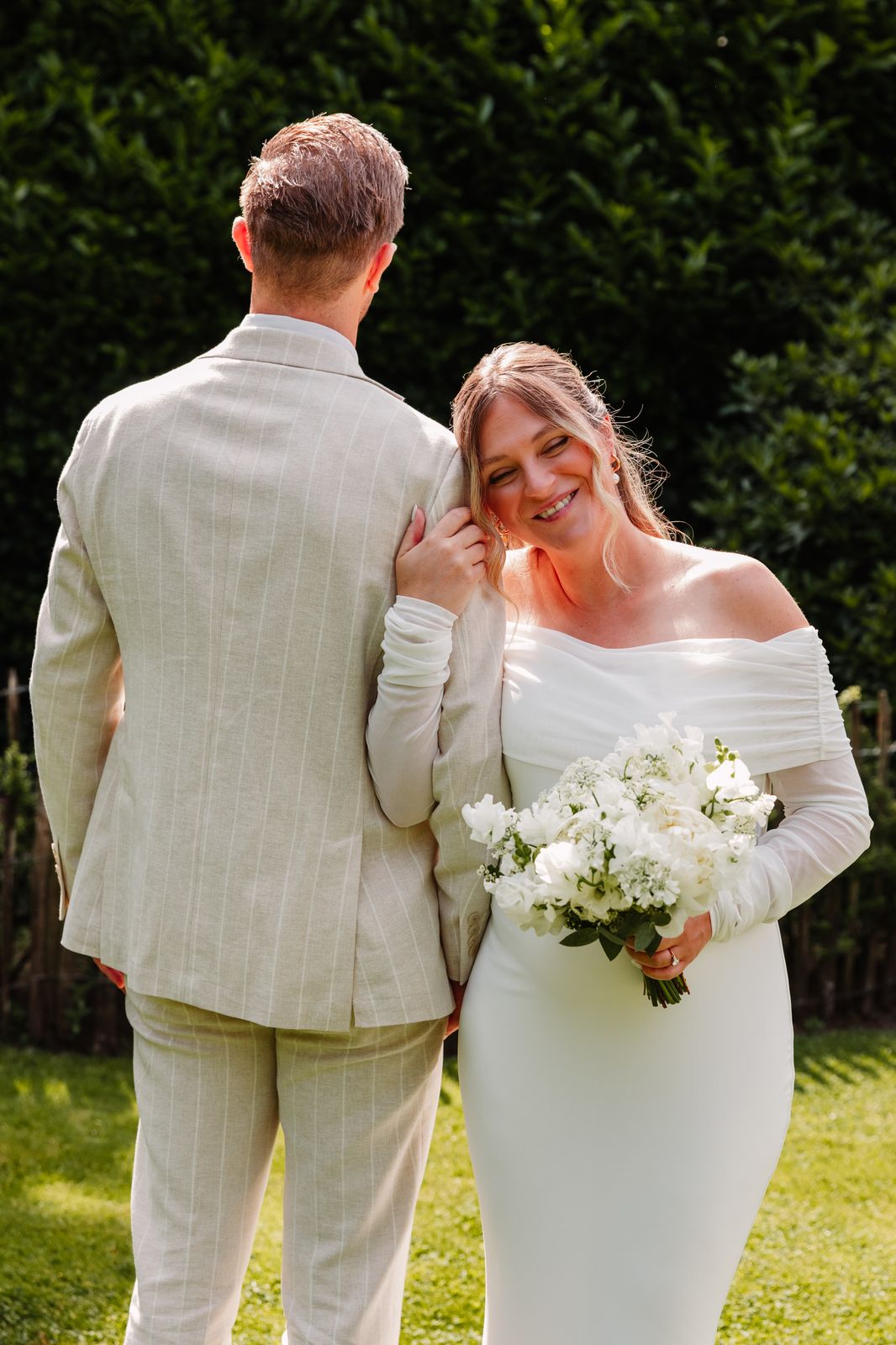 Julie lacht verlegen naast Olivier in de tuin