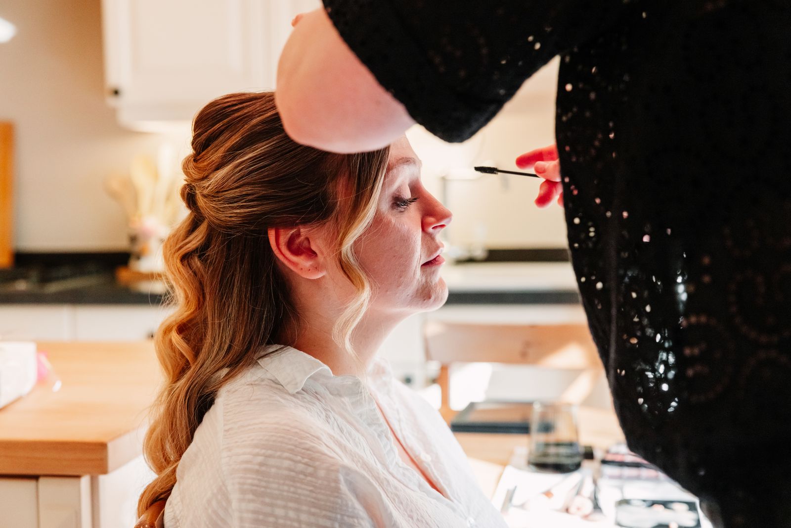 Julie wordt opgemaakt in het ochtendlicht tijdens de getting ready in Schoten