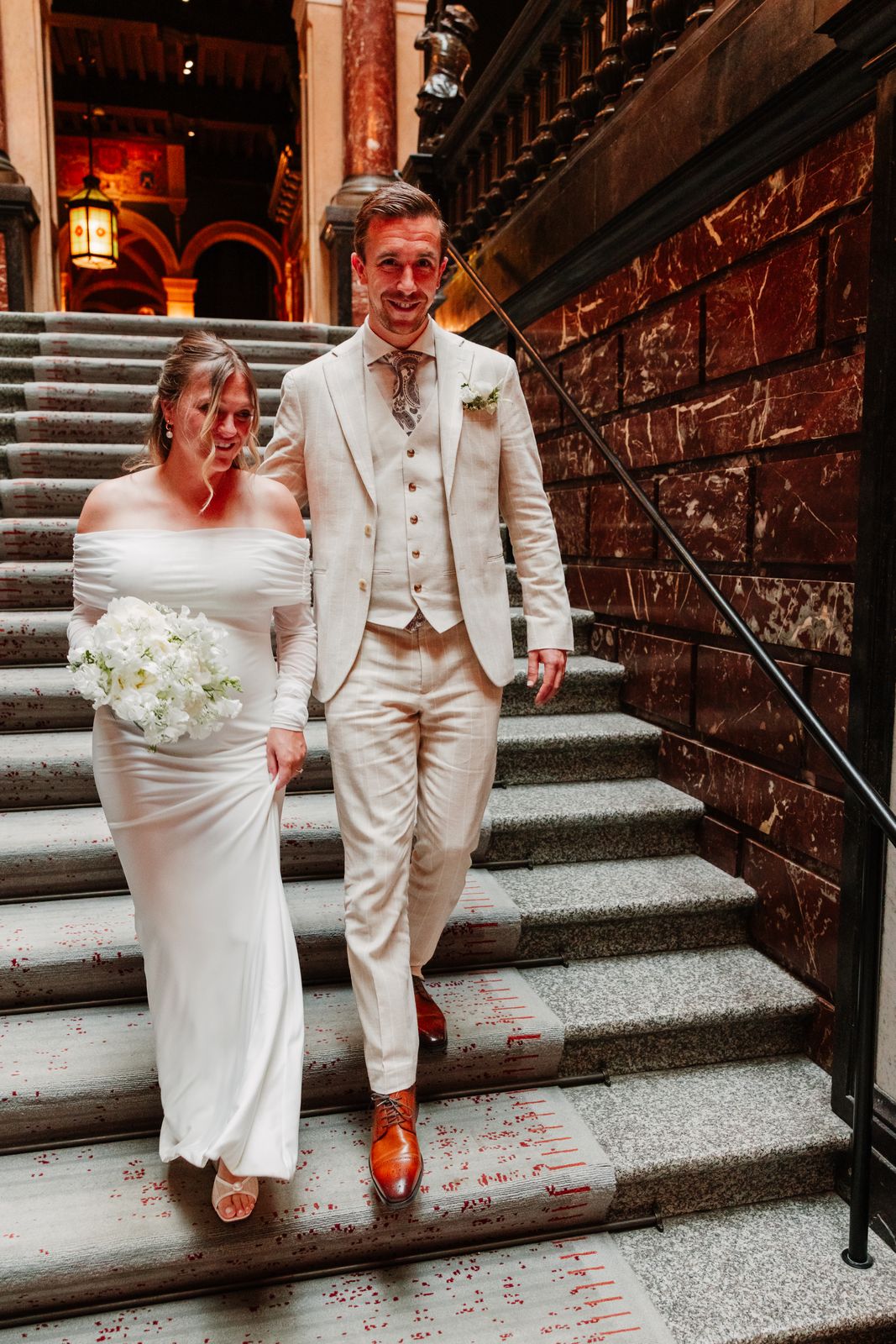 Het bruidspaar daalt de trap af in het stadhuis van Antwerpen