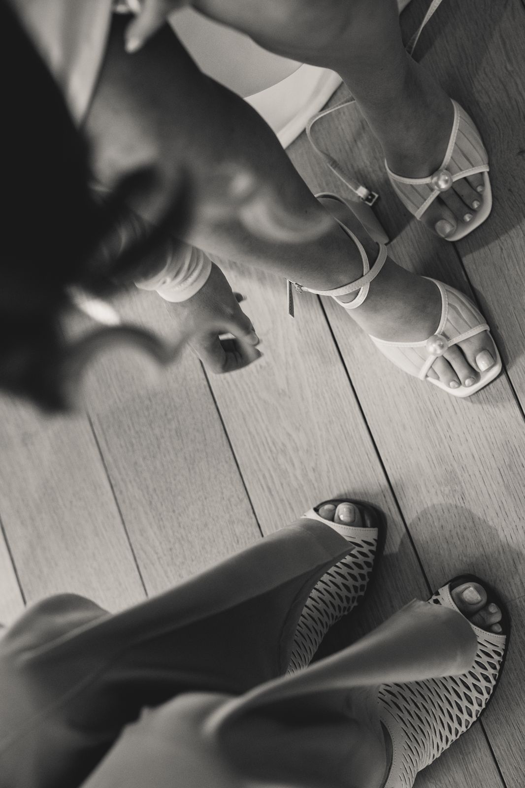 Bruidsschoenen op de houten vloer, monochrome detailfoto