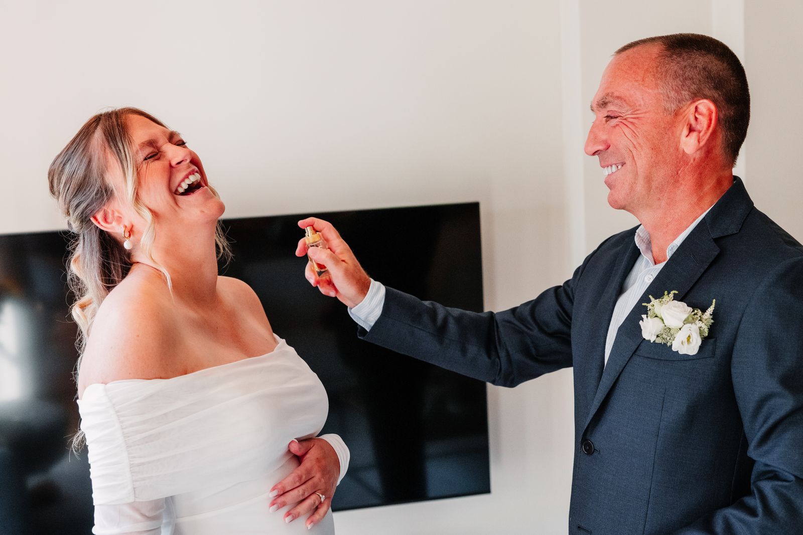 Een uitgelaten lach met familie in de woonkamer, vlak voor de first look
