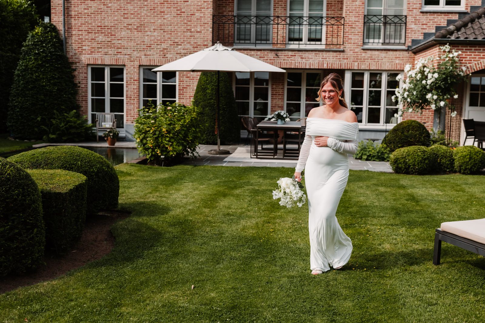 Julie wandelt door de tuin in Schoten naar Olivier voor de first look