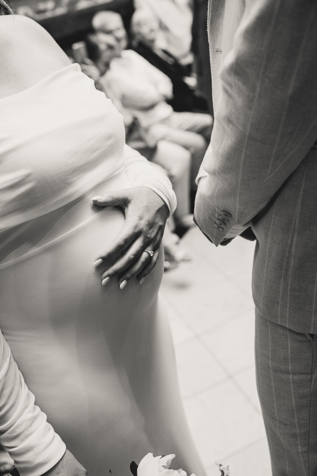 Een hand op de zwangere buik onder het glazen dak van het stadhuis, monochrome foto