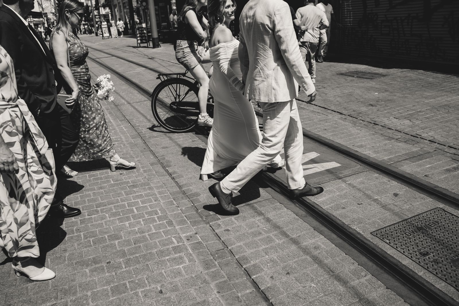 Het bruidspaar steekt de tramsporen over in Antwerpen, monochrome foto