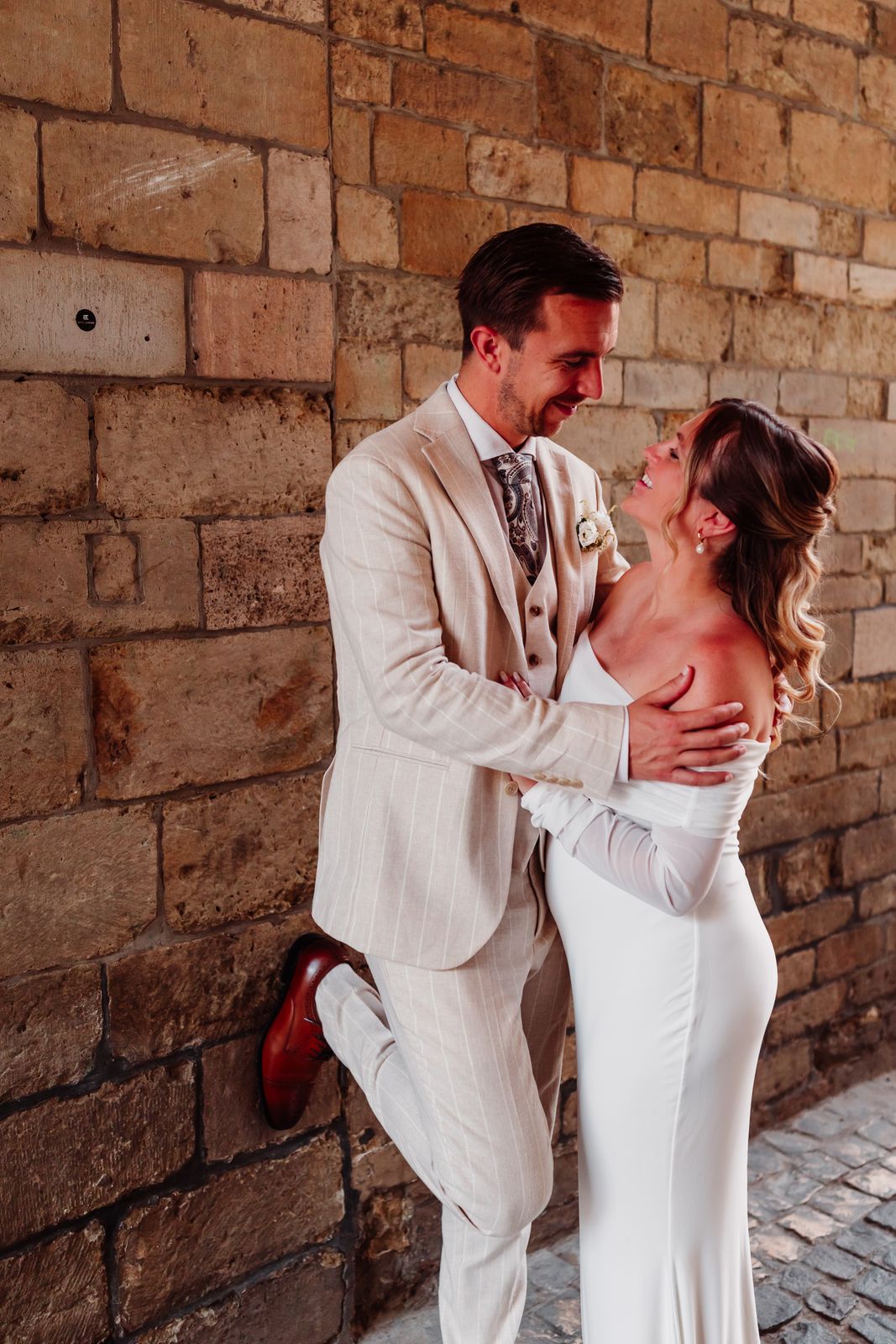Olivier en Julie tegen een oude zandstenen muur in Antwerpen